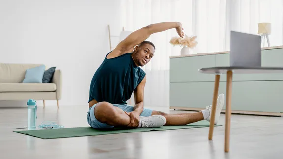 Person performing gentle morning stretches in a bright living room